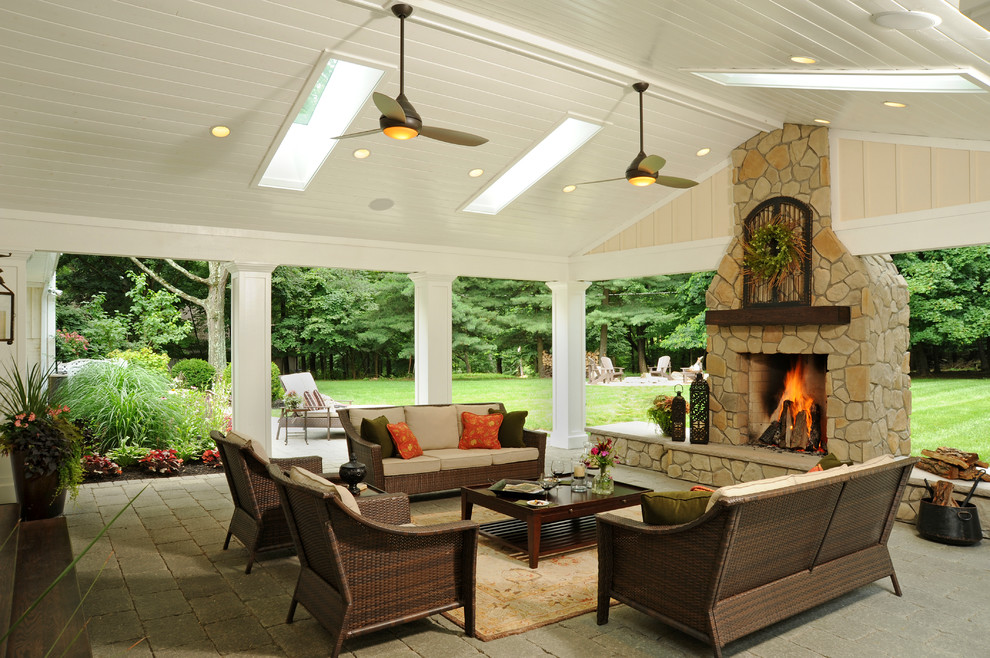 Example of a mid-sized classic backyard brick patio design in Columbus with a fire pit and a roof extension