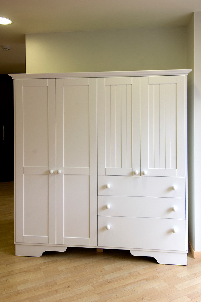 This is an example of a small transitional gender-neutral built-in wardrobe in Other with white cabinets, light hardwood floors and recessed-panel cabinets.