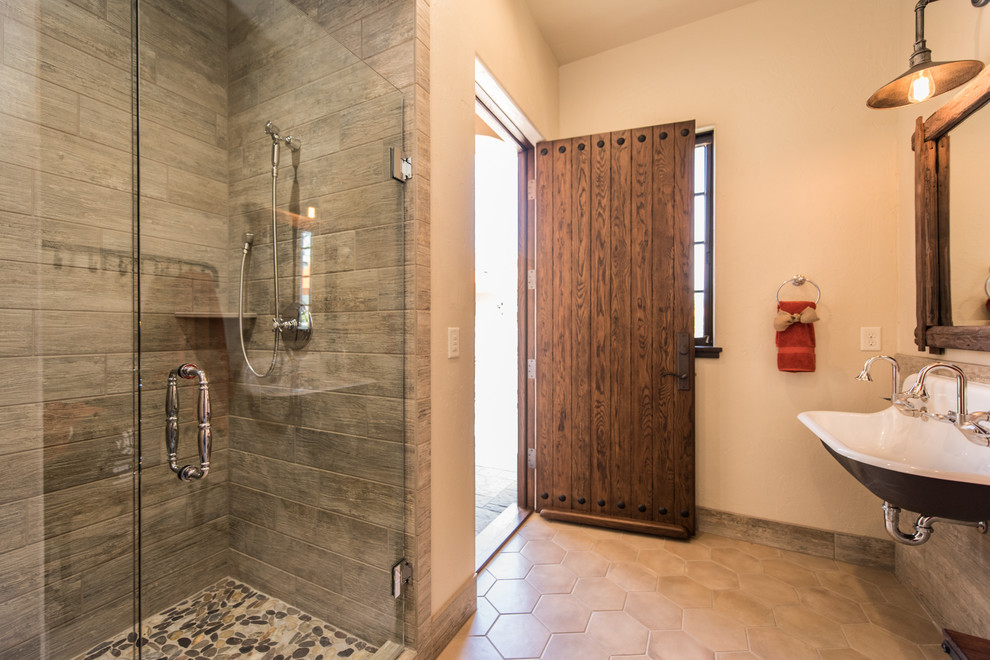 Inspiration for a mediterranean 3/4 bathroom in Portland with an alcove shower, gray tile, a trough sink and a hinged shower door.