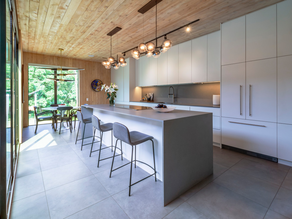 Design ideas for an expansive contemporary eat-in kitchen in Dallas with flat-panel cabinets, grey cabinets, limestone benchtops, grey splashback, cement tiles, with island, grey floor, grey benchtop and wood.