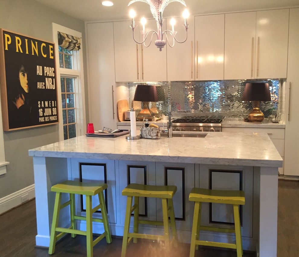 Example of a small transitional l-shaped medium tone wood floor and brown floor enclosed kitchen design with an undermount sink, flat-panel cabinets, white cabinets, marble countertops, mirror backsplash, stainless steel appliances, an island and gray countertops