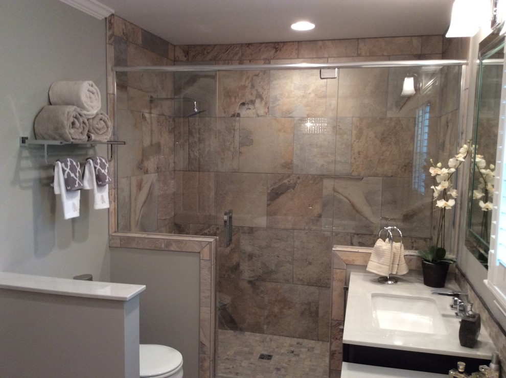 Freestanding bathtub - mid-sized transitional master beige tile and ceramic tile ceramic tile freestanding bathtub idea in Birmingham with an undermount sink, flat-panel cabinets, dark wood cabinets, marble countertops, a two-piece toilet and beige walls