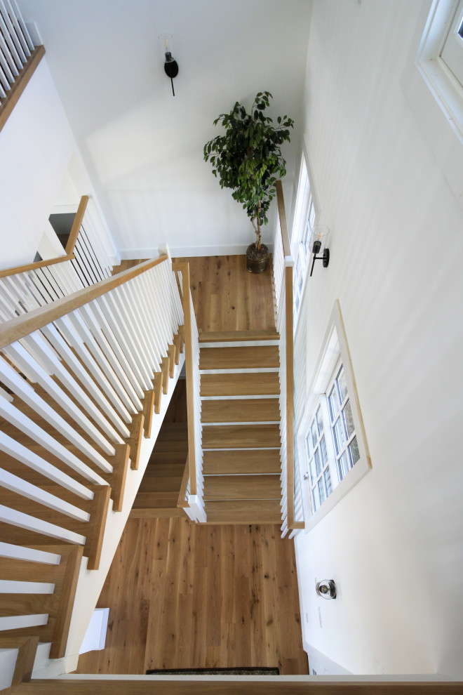 Exemple d'un escalier nature en U de taille moyenne avec des marches en bois, des contremarches en bois, un garde-corps en bois et du lambris de bois.