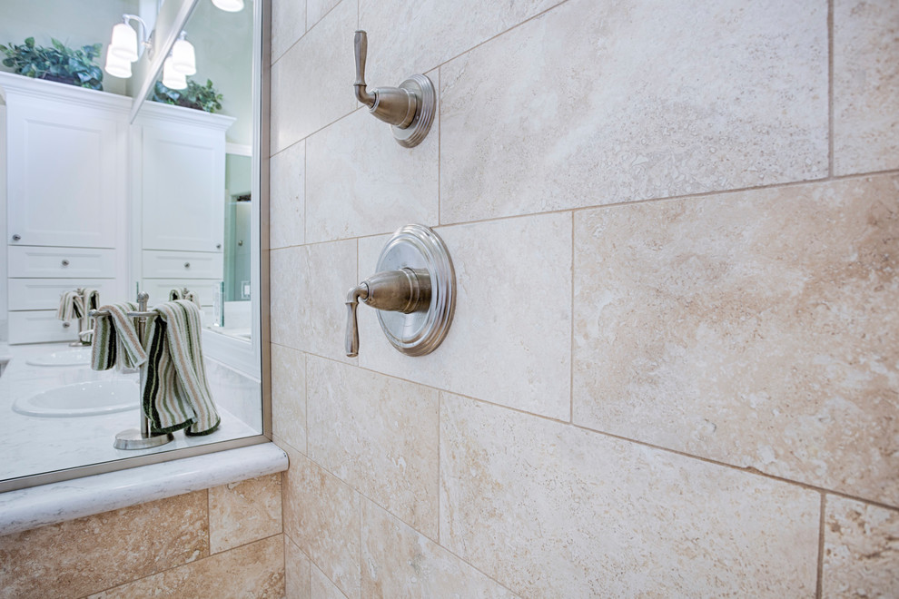 Example of a large transitional master beige tile and travertine tile travertine floor corner shower design in Phoenix with recessed-panel cabinets, white cabinets, green walls, an undermount sink and granite countertops