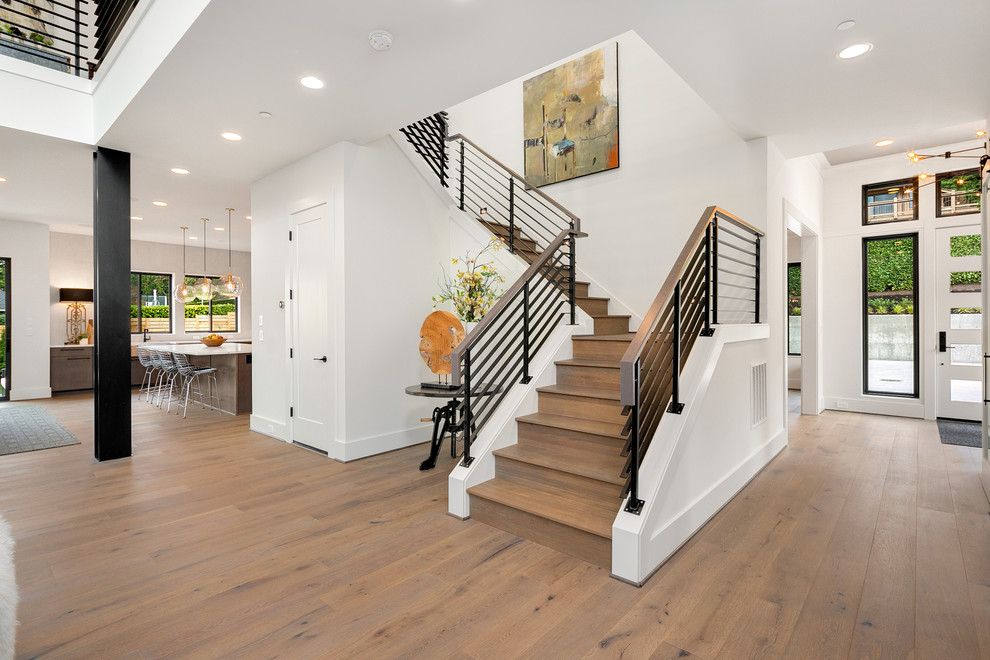 Mid-sized contemporary wood u-shaped staircase in Seattle with wood risers and metal railing.