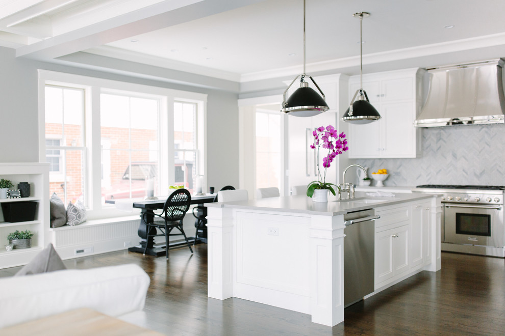 This is an example of a mid-sized eclectic l-shaped eat-in kitchen in Chicago with shaker cabinets, white cabinets, grey splashback, stone tile splashback, stainless steel appliances, dark hardwood floors and with island.