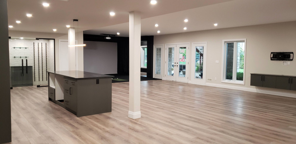 Inspiration for a large transitional walk-out vinyl floor basement remodel with a bar and a tile fireplace
