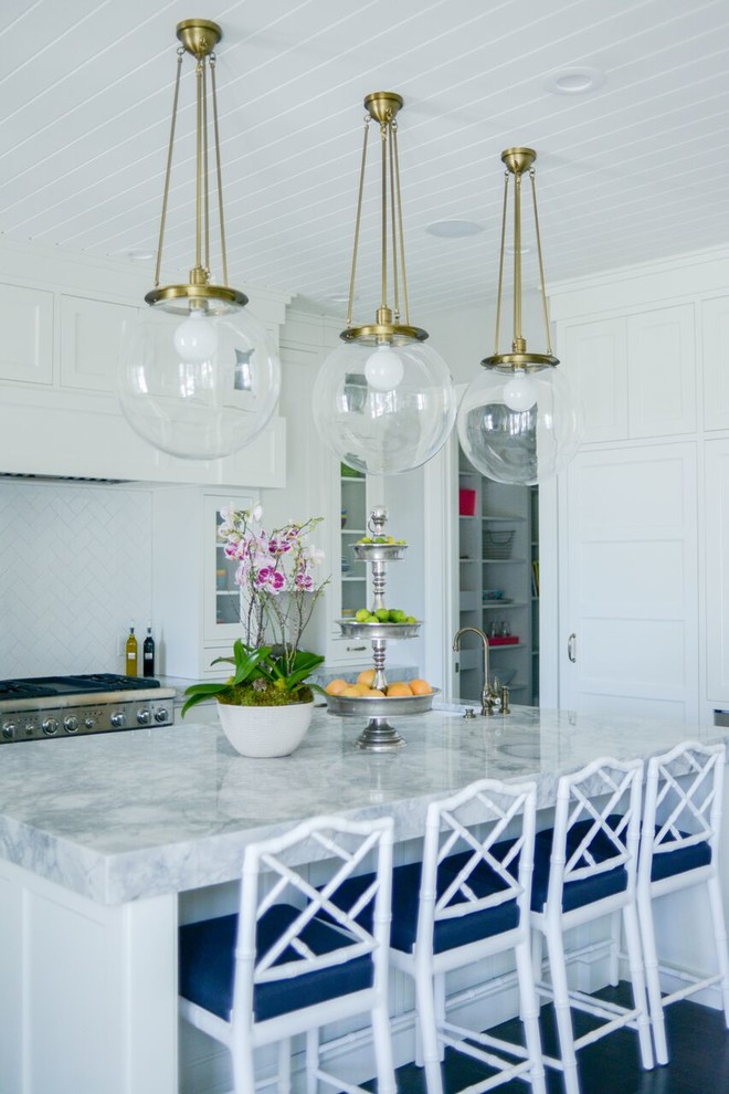 Open concept kitchen - large transitional l-shaped light wood floor open concept kitchen idea in San Diego with a farmhouse sink, shaker cabinets, white cabinets, wood countertops, white backsplash, mosaic tile backsplash, stainless steel appliances and an island