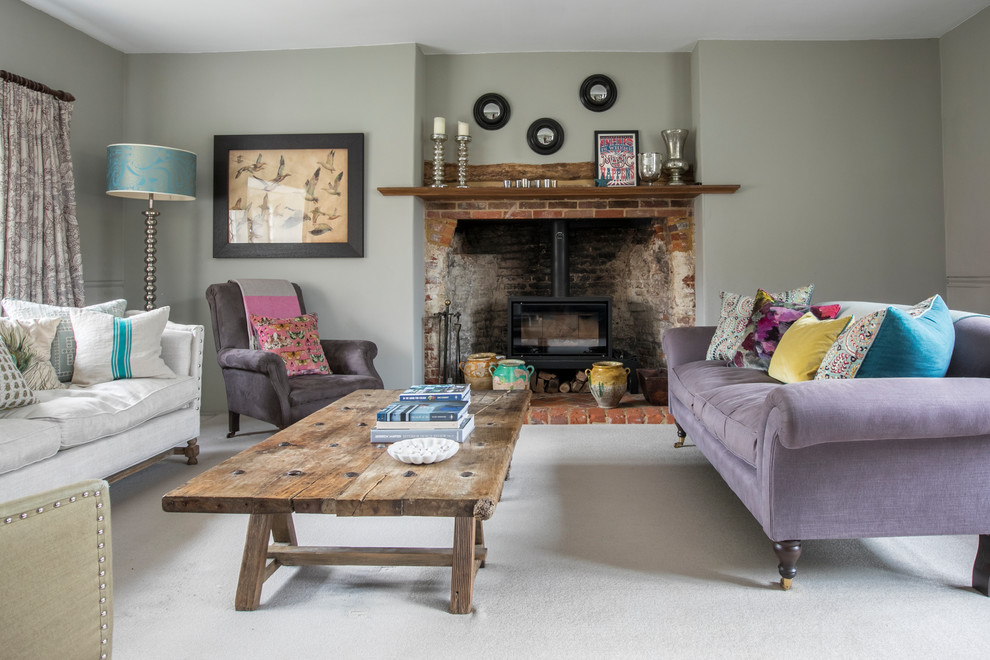 Design ideas for a country living room in Hampshire with grey walls, carpet, a wood stove, a brick fireplace surround and grey floor.