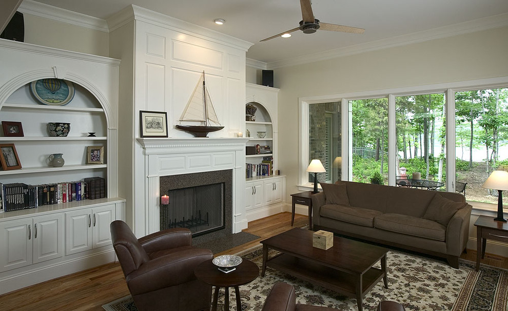 Traditional family room in Charlotte with beige walls, medium hardwood floors, a standard fireplace and no tv.