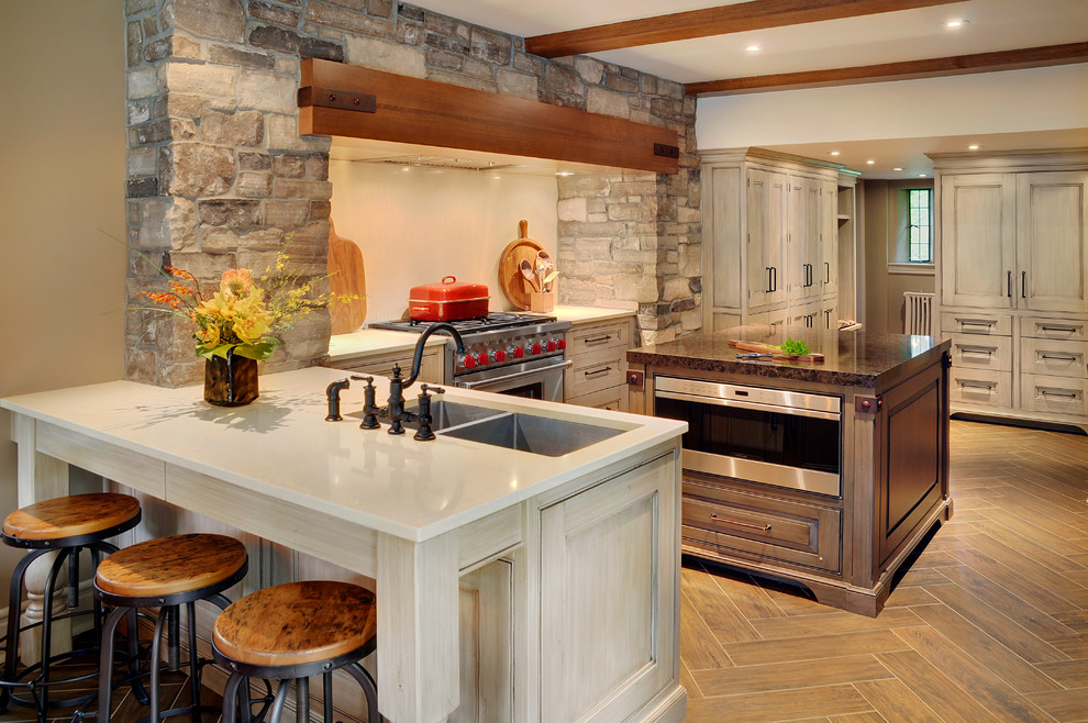 Eat-in kitchen - mid-sized transitional u-shaped porcelain tile eat-in kitchen idea in Toronto with an undermount sink, beaded inset cabinets, granite countertops, stainless steel appliances and an island