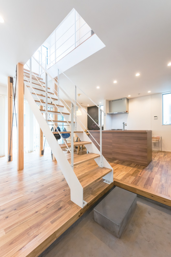 Photo of a mid-sized industrial wood straight staircase in Tokyo Suburbs with open risers and metal railing.