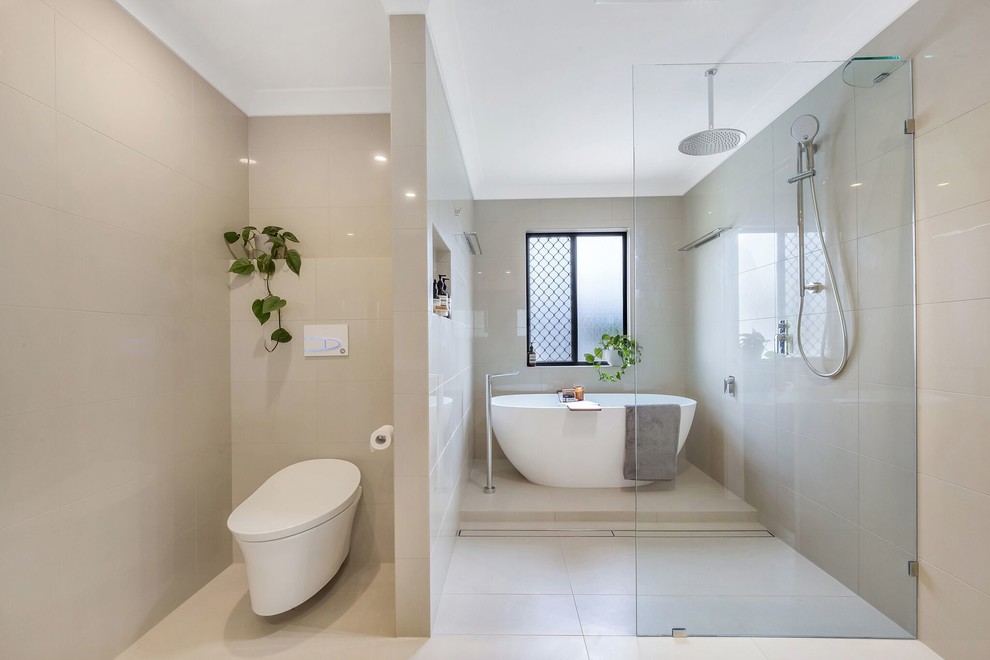 Inspiration for a contemporary bathroom in Brisbane with a freestanding tub, a curbless shower, a wall-mount toilet, beige tile, beige walls, beige floor and an open shower.