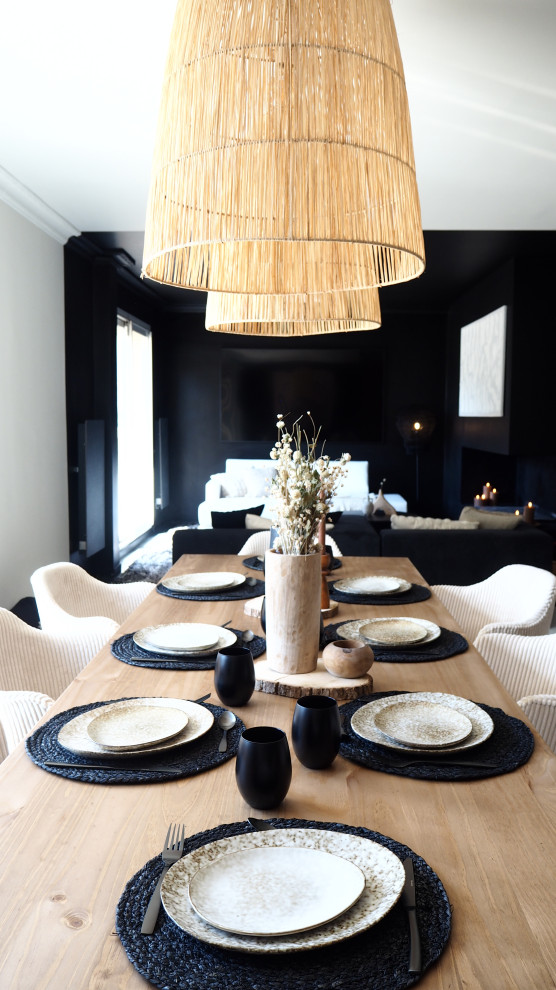 Immagine di una grande sala da pranzo aperta verso il soggiorno classica con pareti nere, pavimento in legno verniciato e pavimento bianco