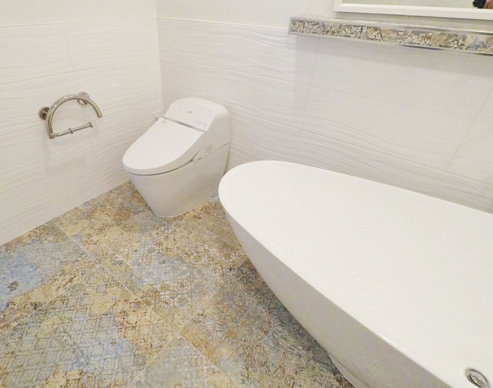 This is an example of a large modern master wet room bathroom in Other with shaker cabinets, beige cabinets, a freestanding tub, a one-piece toilet, white tile, ceramic tile, white walls, porcelain floors, an undermount sink, multi-coloured floor, an open shower, beige benchtops and granite benchtops.