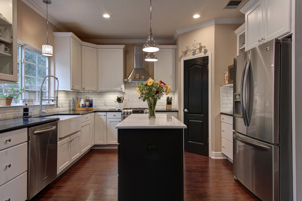 Transitional u-shaped eat-in kitchen photo in Austin with a farmhouse sink, recessed-panel cabinets, white cabinets, quartz countertops, white backsplash, subway tile backsplash and stainless steel appliances