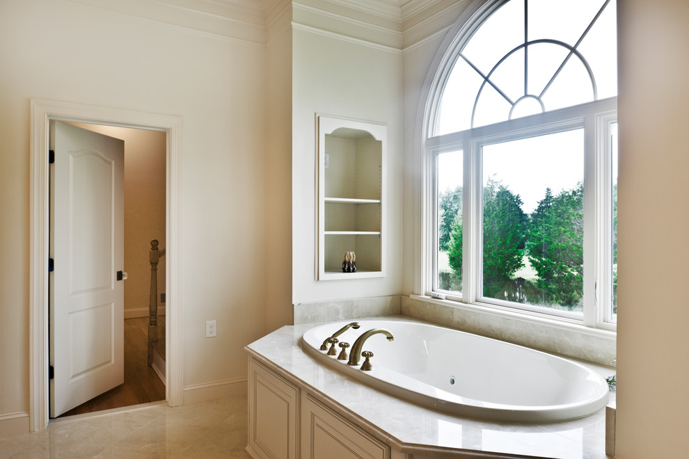 Mid-sized modern master bathroom in DC Metro with white cabinets, a hot tub, a double shower, a one-piece toilet, white tile, white walls, marble floors, an undermount sink, beige floor, a hinged shower door and beige benchtops.