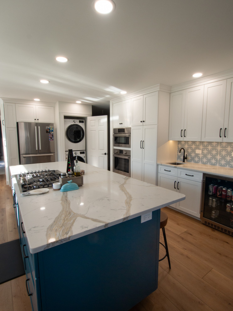 Photo of a medium sized contemporary enclosed kitchen in Chicago with a submerged sink, recessed-panel cabinets, white cabinets, blue splashback, stainless steel appliances, medium hardwood flooring, an island, brown floors and yellow worktops.