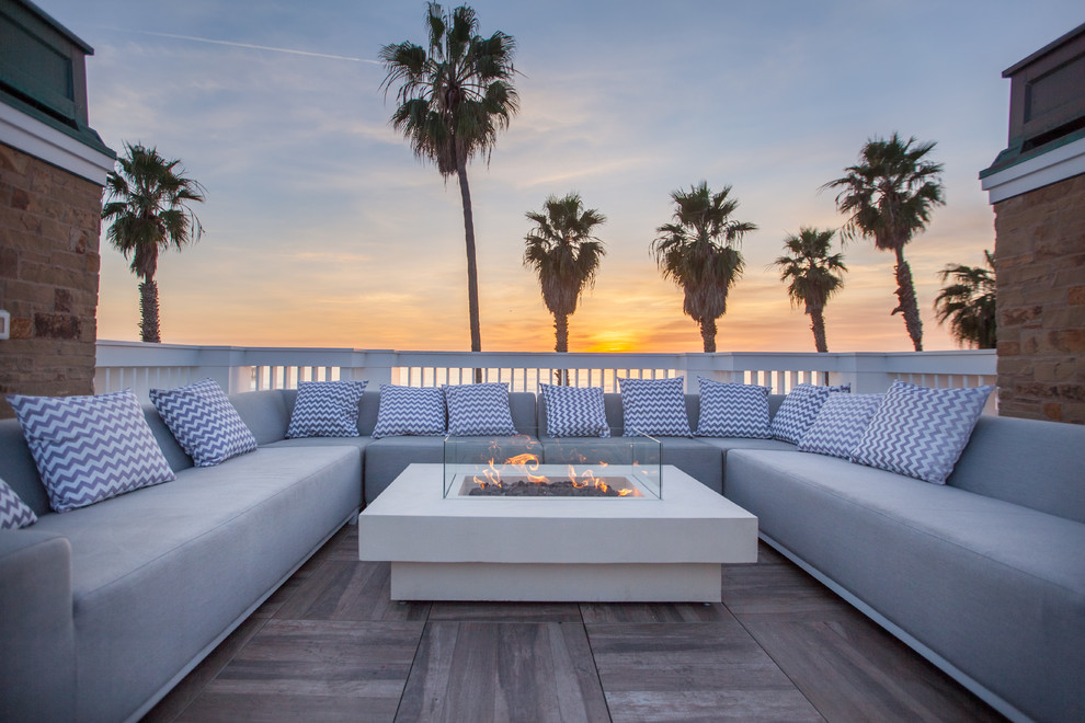 Inspiration for a large beach style backyard deck in Los Angeles with a fire feature and no cover.