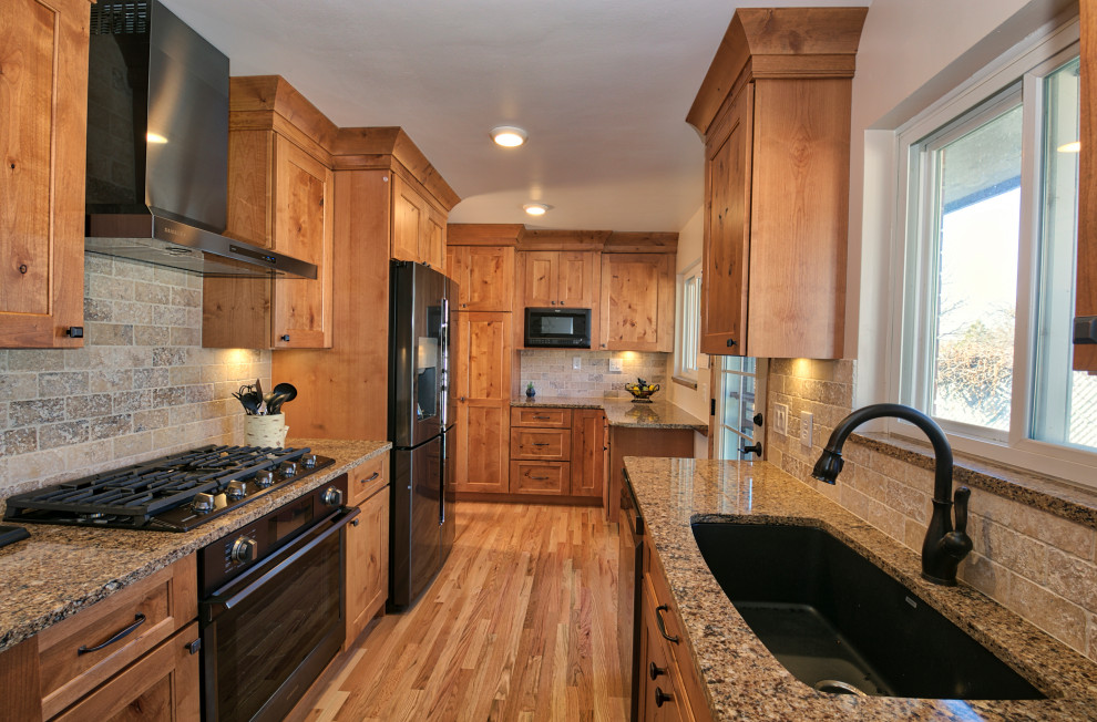 Mid-sized mountain style galley medium tone wood floor and brown floor eat-in kitchen photo in Denver with an undermount sink, shaker cabinets, medium tone wood cabinets, quartz countertops, gray backsplash, stone tile backsplash, black appliances, no island and brown countertops