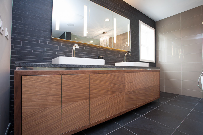 This is an example of a large contemporary master bathroom in Chicago with gray tile, a vessel sink, flat-panel cabinets, light wood cabinets, a freestanding tub, an alcove shower, matchstick tile, multi-coloured walls, slate floors and concrete benchtops.