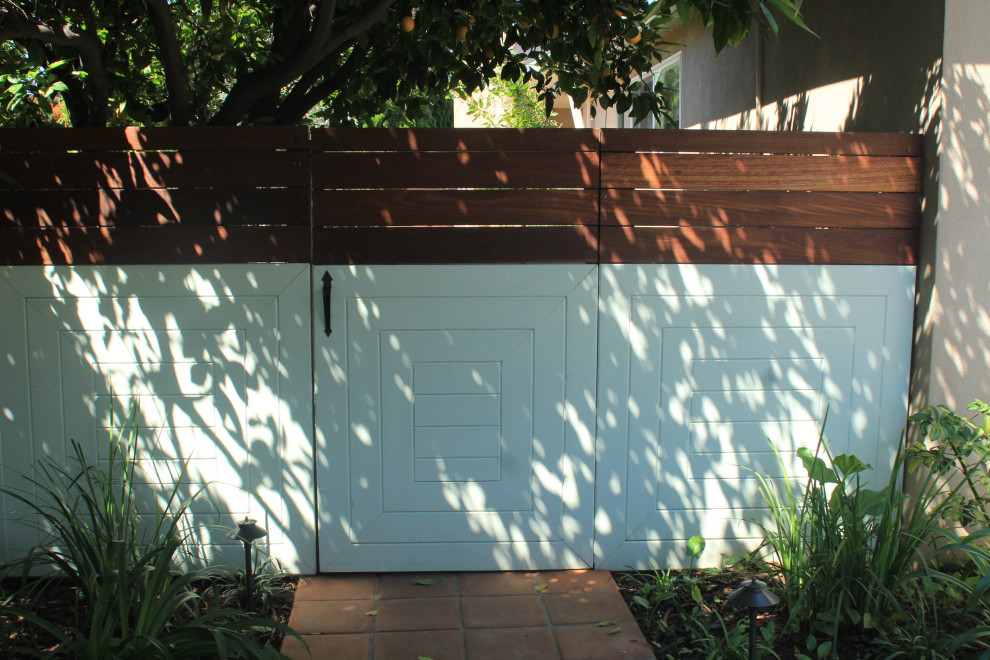 Immagine di un giardino eclettico esposto a mezz'ombra di medie dimensioni e davanti casa in primavera con pavimentazioni in pietra naturale e recinzione in legno