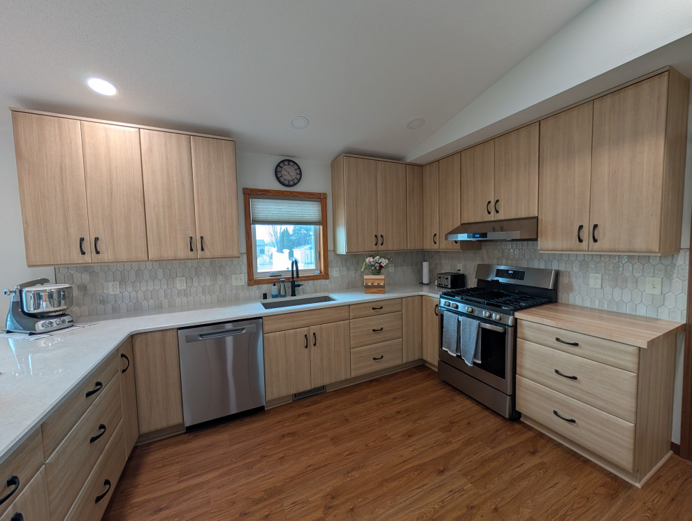 Example of a mid-sized transitional u-shaped eat-in kitchen design with flat-panel cabinets, light wood cabinets and quartz countertops