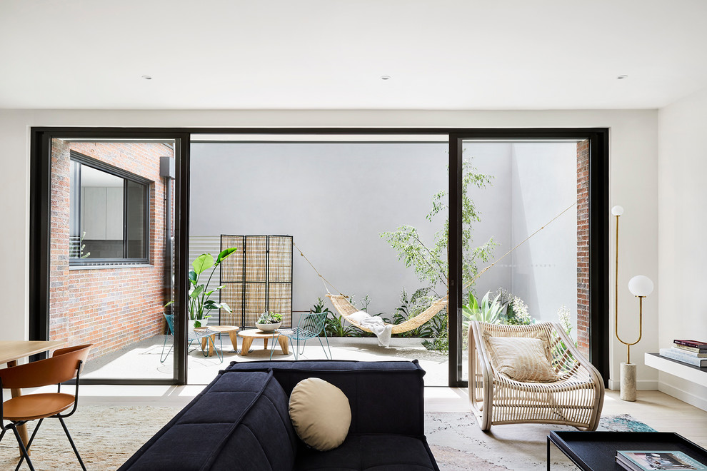 This is an example of a mid-sized contemporary living room in Melbourne with light hardwood floors.