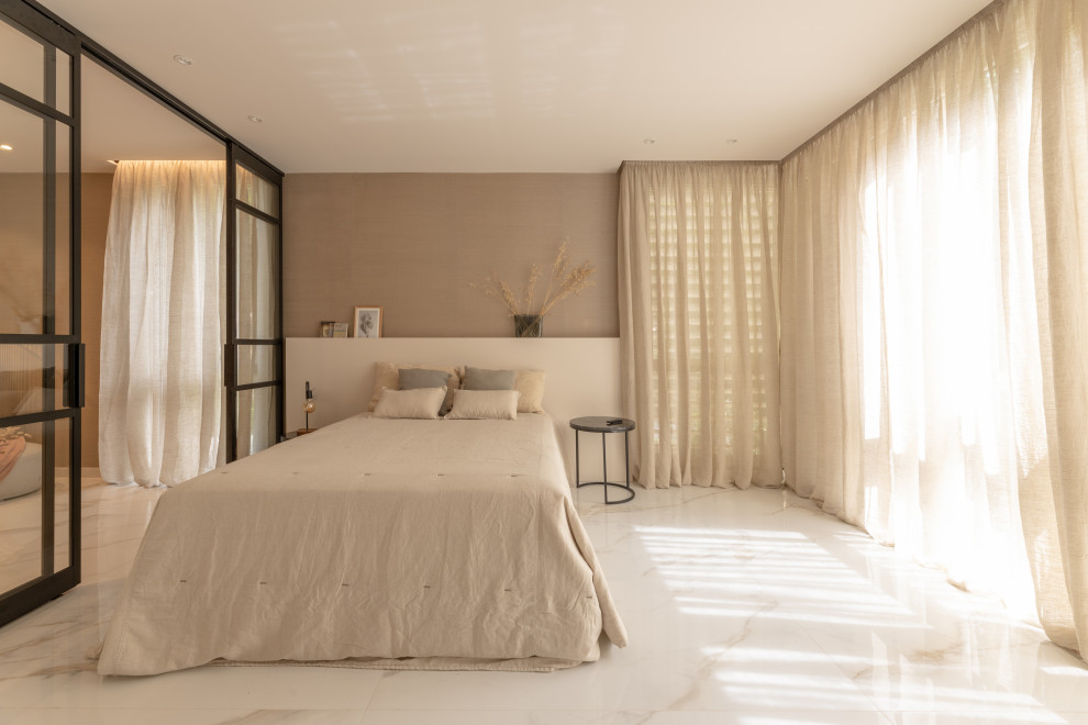 Diseño de dormitorio tradicional renovado grande con paredes beige, suelo de mármol, suelo beige y papel pintado