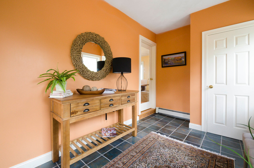 Inspiration for a mid-sized beach style foyer in Boston with orange walls, slate floors and black floor.