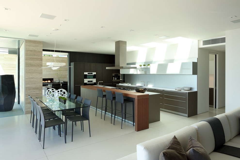 Design ideas for a mid-sized contemporary l-shaped eat-in kitchen in Los Angeles with an undermount sink, flat-panel cabinets, grey cabinets, white splashback, stainless steel appliances, with island, ceramic splashback, ceramic floors and beige floor.
