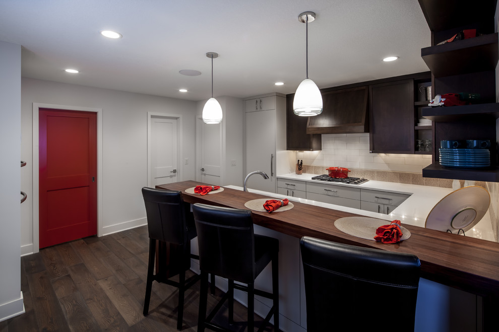 Design ideas for a mid-sized contemporary u-shaped separate kitchen in Minneapolis with an undermount sink, shaker cabinets, wood benchtops, white splashback, ceramic splashback, panelled appliances, dark hardwood floors and a peninsula.