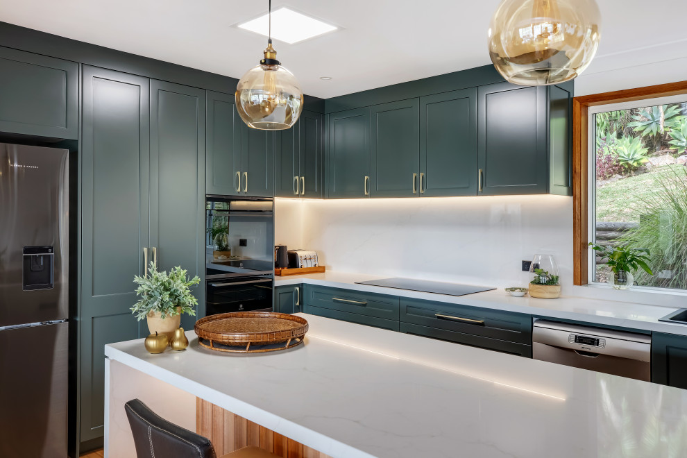 Eat-in kitchen - large transitional l-shaped medium tone wood floor and multicolored floor eat-in kitchen idea in Sydney with a drop-in sink, shaker cabinets, green cabinets, quartz countertops, white backsplash, quartz backsplash, black appliances, an island and white countertops