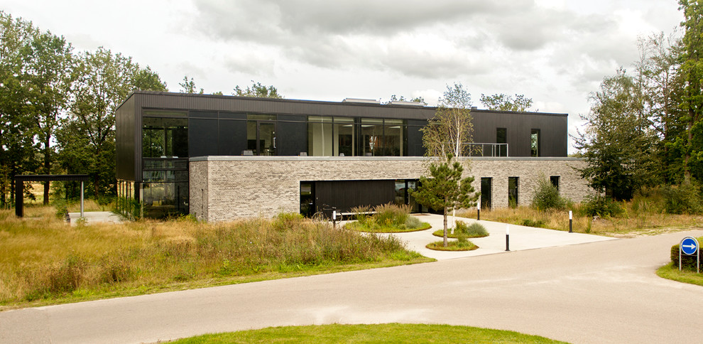 Expansive modern two-storey black exterior in Aarhus with mixed siding and a flat roof.