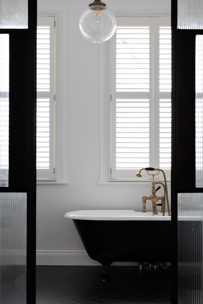 Пример оригинального дизайна: ванная комната в современном стиле с отдельно стоящей ванной, белой плиткой, полом из керамической плитки и черным полом