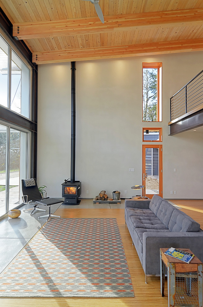 This is an example of a contemporary living room in Portland with white walls and a wood stove.