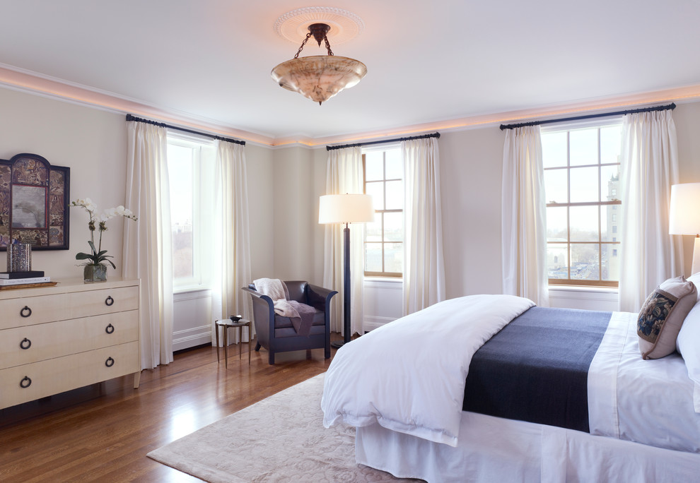 Inspiration for a transitional bedroom in New York with beige walls and medium hardwood floors.