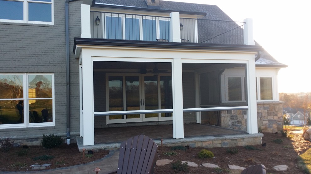 Large traditional backyard screened-in verandah in Louisville with a roof extension and natural stone pavers.