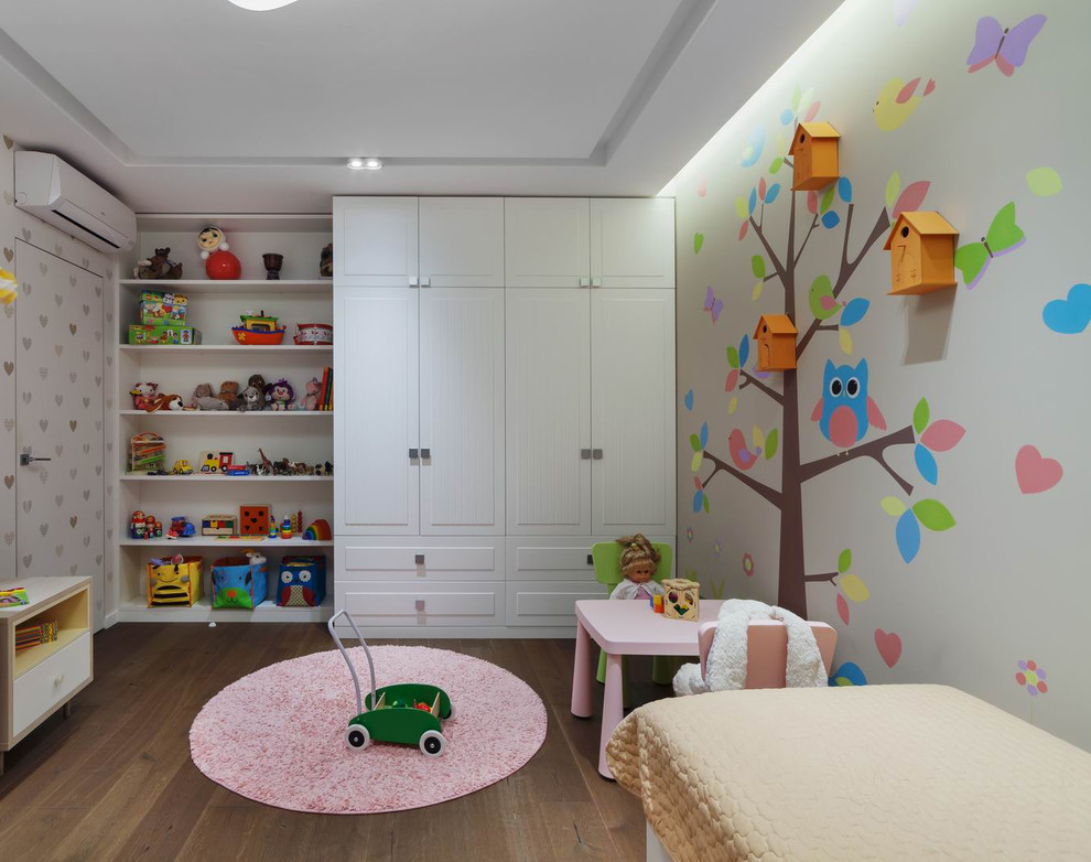 This is an example of a mid-sized contemporary kids' room for girls in Yekaterinburg with beige walls, medium hardwood floors and brown floor.
