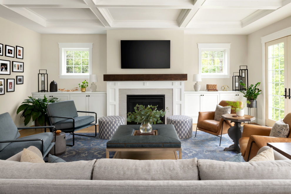 Photo of a transitional family room in DC Metro with light hardwood floors, a standard fireplace, a tile fireplace surround, a wall-mounted tv and coffered.
