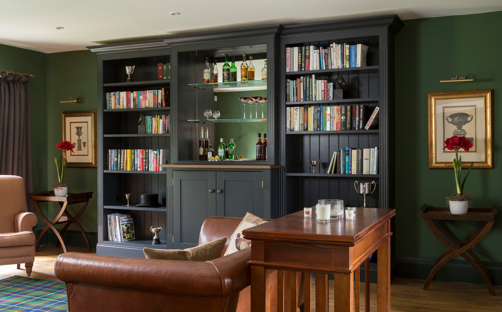 This is an example of a mid-sized traditional family room in Gloucestershire with a home bar, green walls, medium hardwood floors and brown floor.