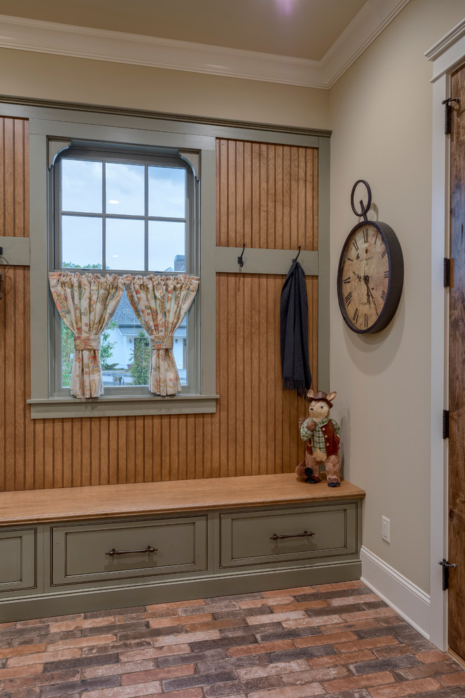 Inspiration for a large country u-shaped utility room in Other with a farmhouse sink, recessed-panel cabinets, green cabinets, granite benchtops, beige walls, brick floors, a side-by-side washer and dryer, multi-coloured floor and brown benchtop.