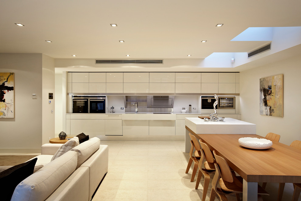 Contemporary single-wall open plan kitchen in Melbourne with a double-bowl sink, flat-panel cabinets, white cabinets and stainless steel appliances.