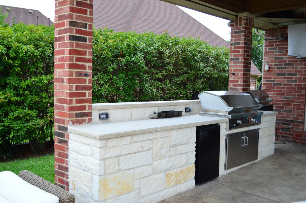 Inspiration for a large eclectic backyard patio in Dallas with an outdoor kitchen and natural stone pavers.