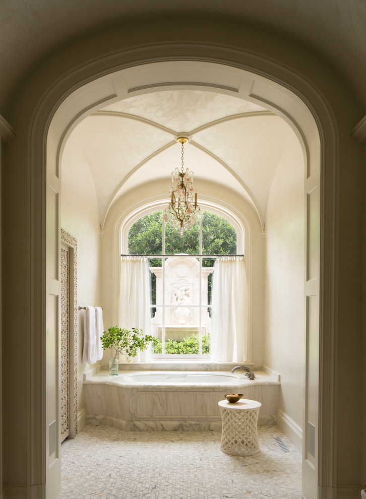 Photo of a mediterranean master bathroom in Dallas with an undermount tub, beige walls and beige floor.