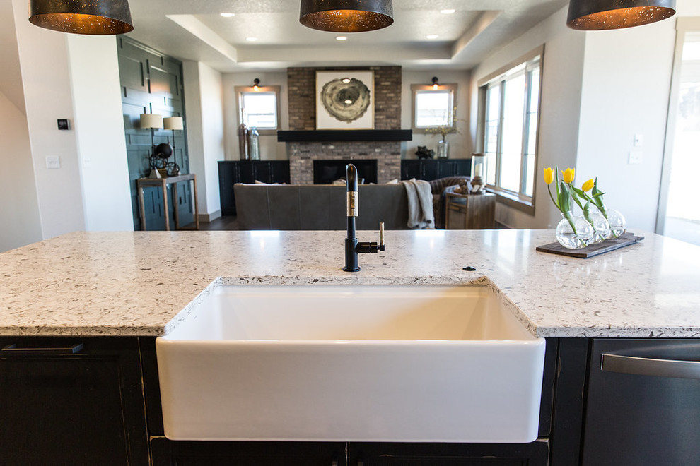 Example of a large transitional u-shaped medium tone wood floor and brown floor open concept kitchen design with a farmhouse sink, shaker cabinets, medium tone wood cabinets, quartz countertops, beige backsplash, ceramic backsplash, black appliances, an island and multicolored countertops