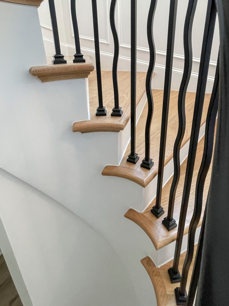 Foto de escalera suspendida tradicional renovada grande con escalones de madera, contrahuellas de madera pintada, barandilla de varios materiales y boiserie