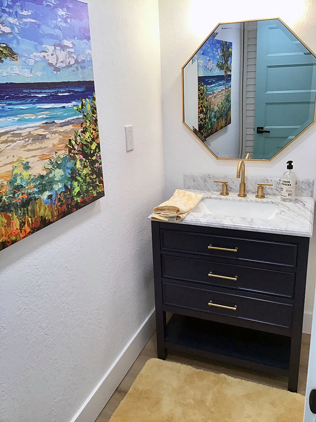 Photo of a small beach style 3/4 bathroom in Orlando with raised-panel cabinets, blue cabinets, white walls, laminate floors, an undermount sink, engineered quartz benchtops, brown floor, grey benchtops, a single vanity and a freestanding vanity.