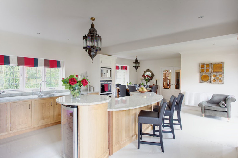 Design ideas for a contemporary kitchen/diner in Cheshire with a built-in sink, shaker cabinets, white cabinets, granite worktops, grey splashback, stainless steel appliances, a breakfast bar and grey worktops.