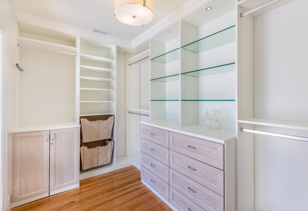 Photo of a large country gender-neutral walk-in wardrobe in Los Angeles with open cabinets, white cabinets, dark hardwood floors and brown floor.